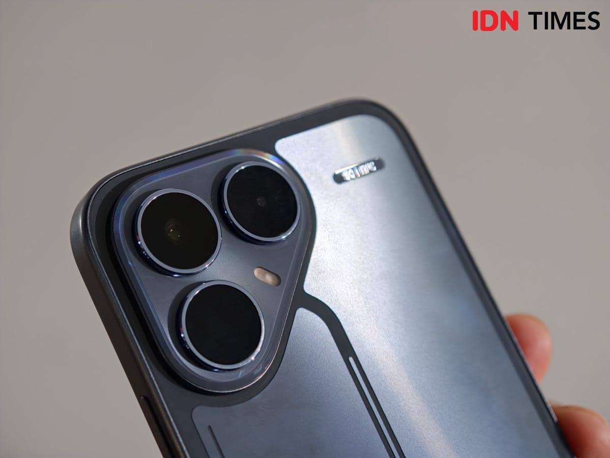 Bagian belakang smartphone TECNO POVA 8 5G dengan tiga kamera besar dan desain metalik yang elegan dipegang oleh seseorang.