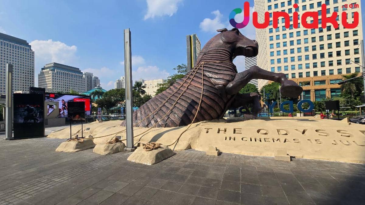Patung besar Kuda Troya berwarna cokelat dipasang di area luar Senayan City Jakarta dengan latar gedung tinggi dan langit cerah.