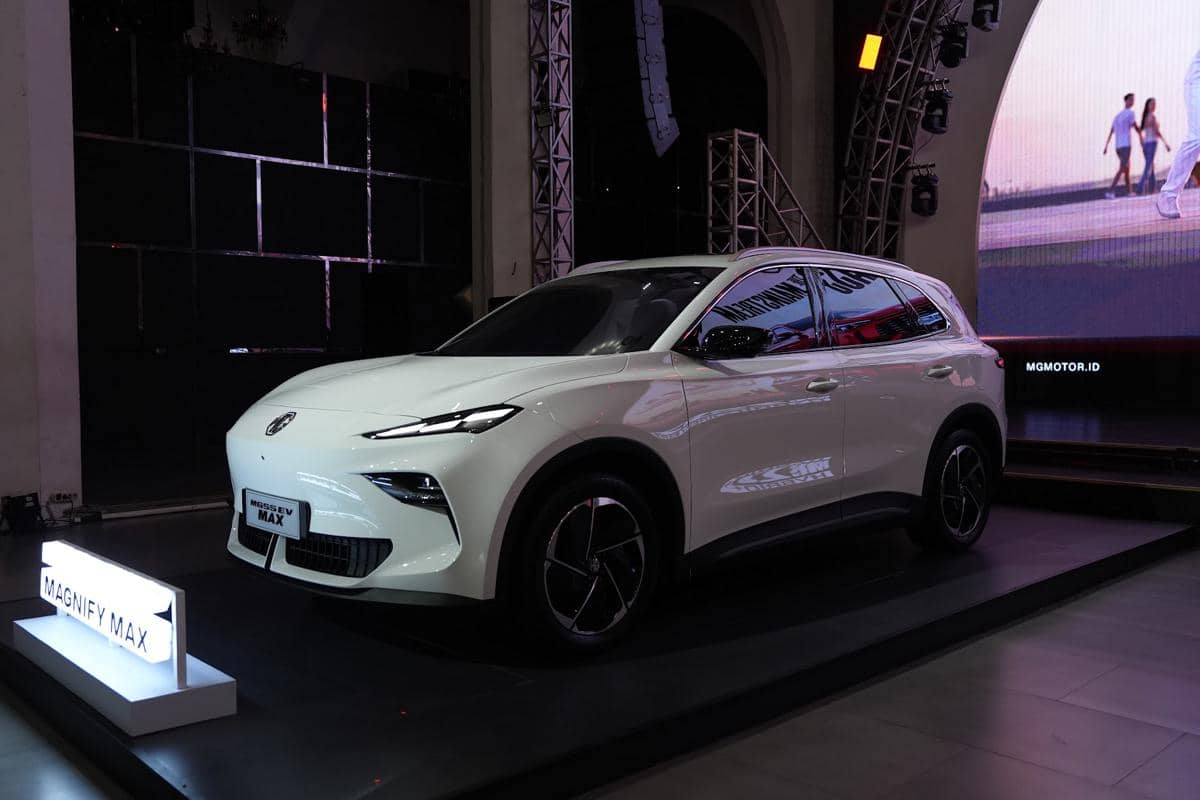 Mobil SUV listrik MG Magnify Max berwarna putih dipamerkan di atas panggung dengan pencahayaan modern di sebuah acara peluncuran.