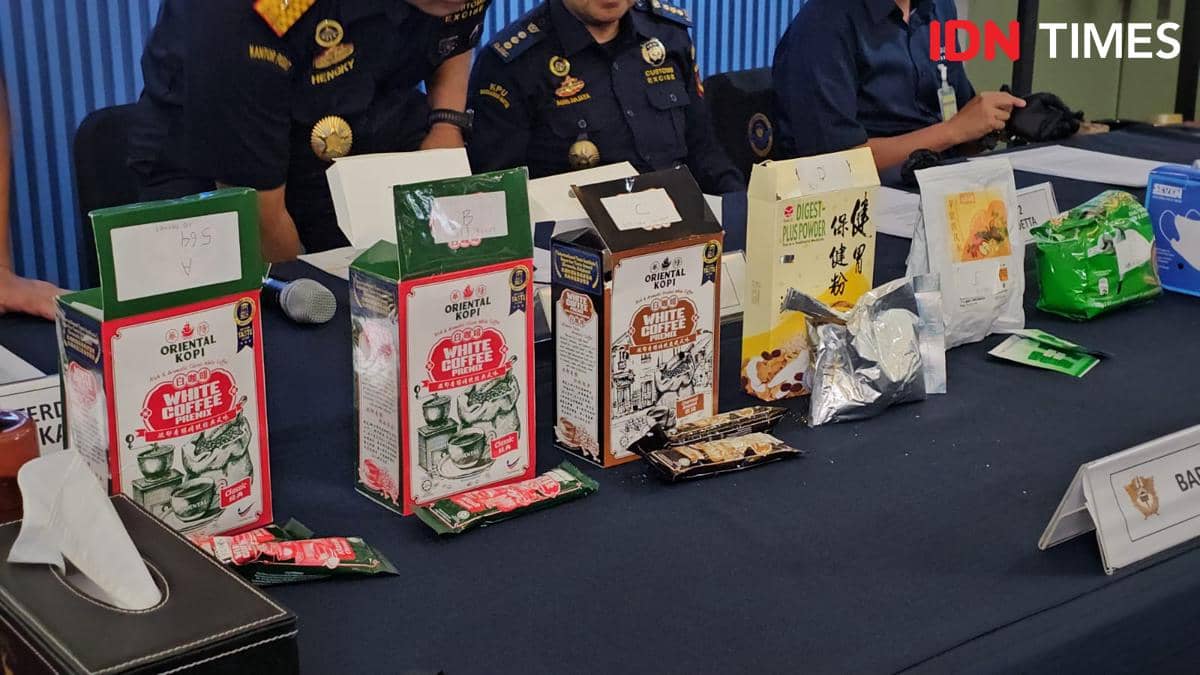 Petugas Bea Cukai Soekarno-Hatta memperlihatkan barang bukti penyelundupan bahan baku Happy Water berupa kemasan kopi dan produk serbuk di meja konferensi pers.