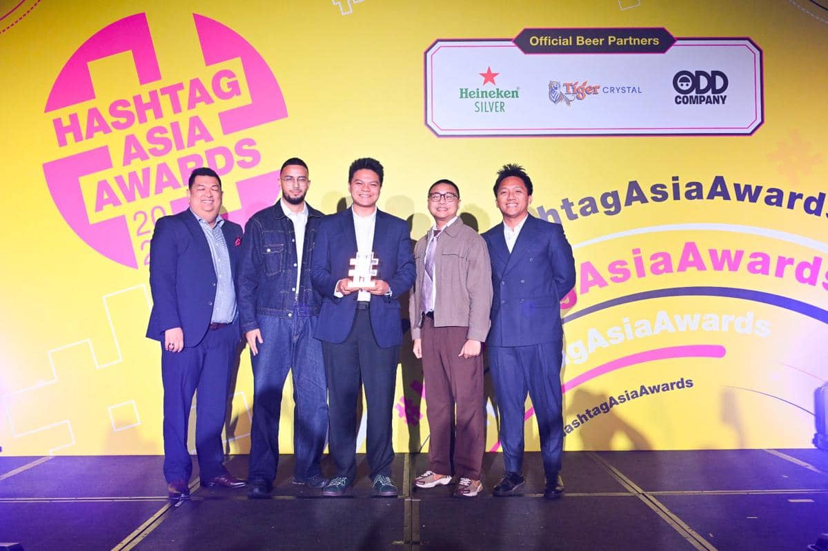 Lima pria berpose di panggung dengan latar belakang kuning bertuliskan Hashtag Asia Awards 2026, salah satunya memegang trofi penghargaan.