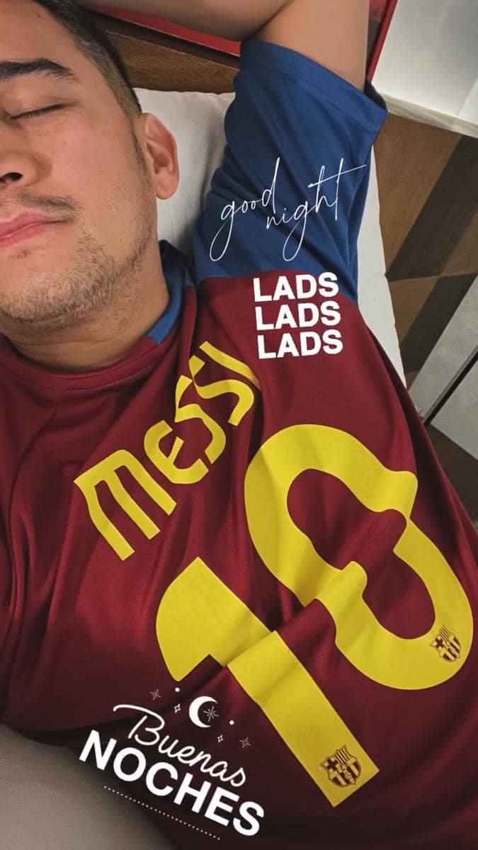 Seorang pria berbaring sambil mengenakan jersey sepak bola bernomor 10 bertuliskan Messi dengan tulisan 'good night' di atasnya.