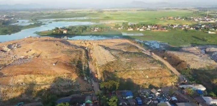 Pemandangan udara TPA Tamangapa di Makassar dengan area penimbunan sampah besar dan permukiman di sekitarnya.