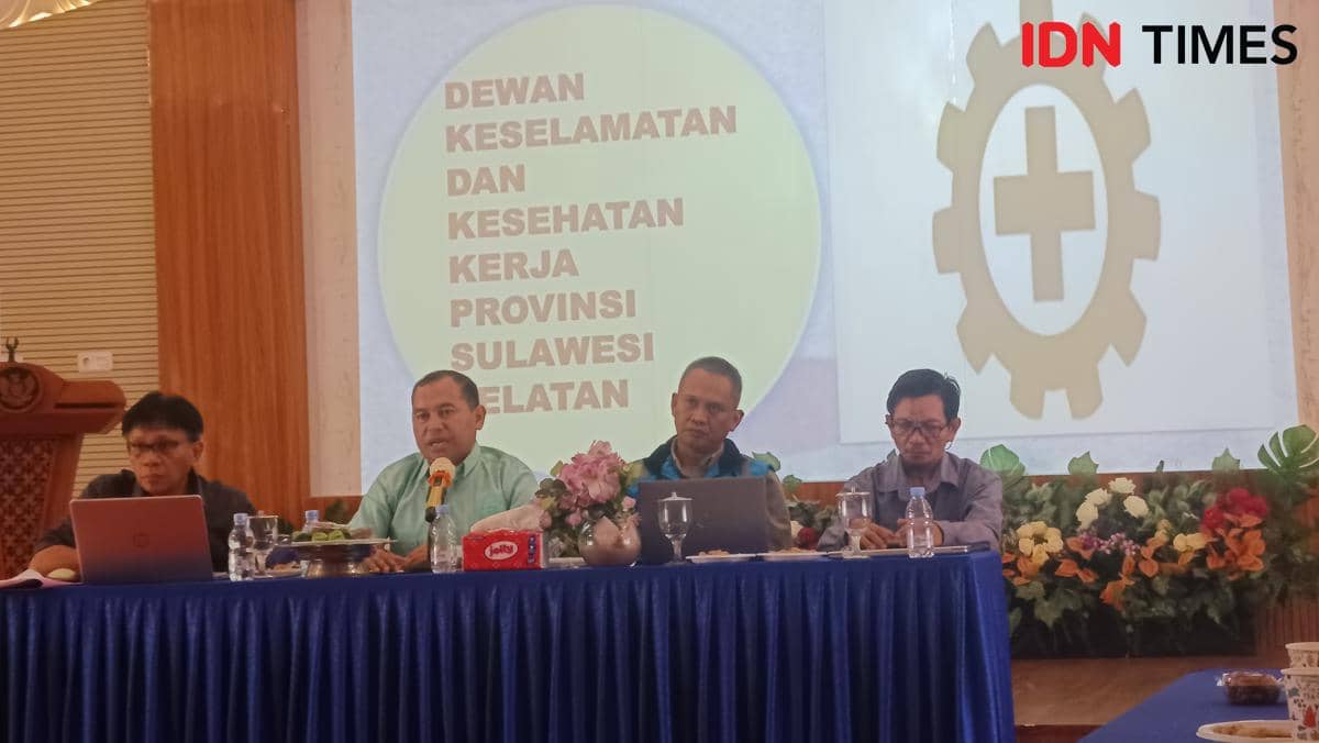 Empat pria duduk di meja panel dengan latar belakang logo Dewan Keselamatan dan Kesehatan Kerja Provinsi Sulawesi Selatan saat acara sosialisasi program kerja.