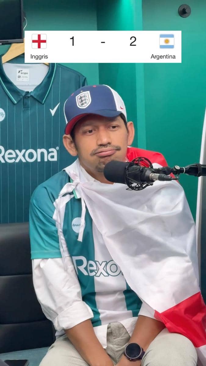 Seorang pria mengenakan topi tim Inggris dan bendera nasional di pundaknya tampak kecewa setelah Inggris kalah 1-2 dari Argentina di Piala Dunia 2026.