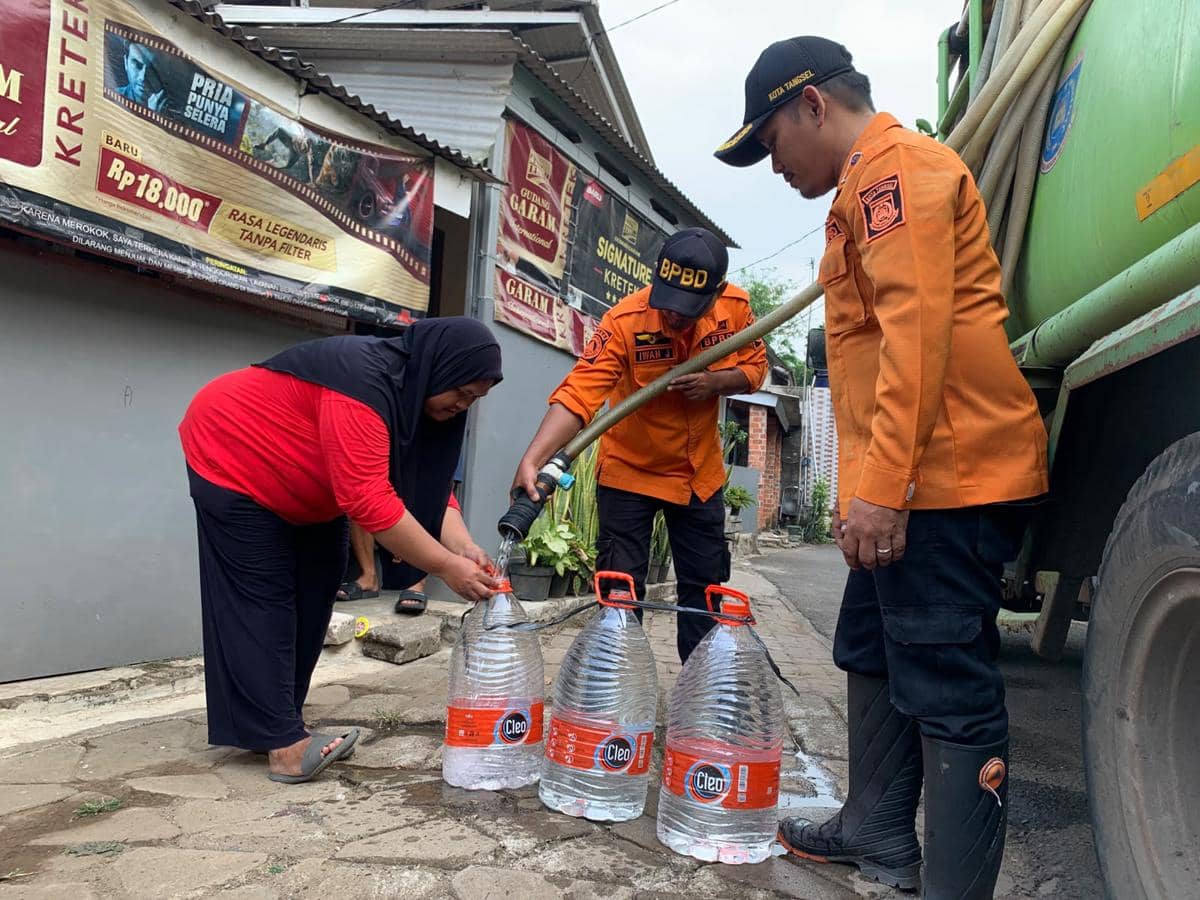 Petugas BPBD Tangsel menyalurkan air bersih kepada warga yang terdampak kekeringan menggunakan truk tangki di kawasan pemukiman.