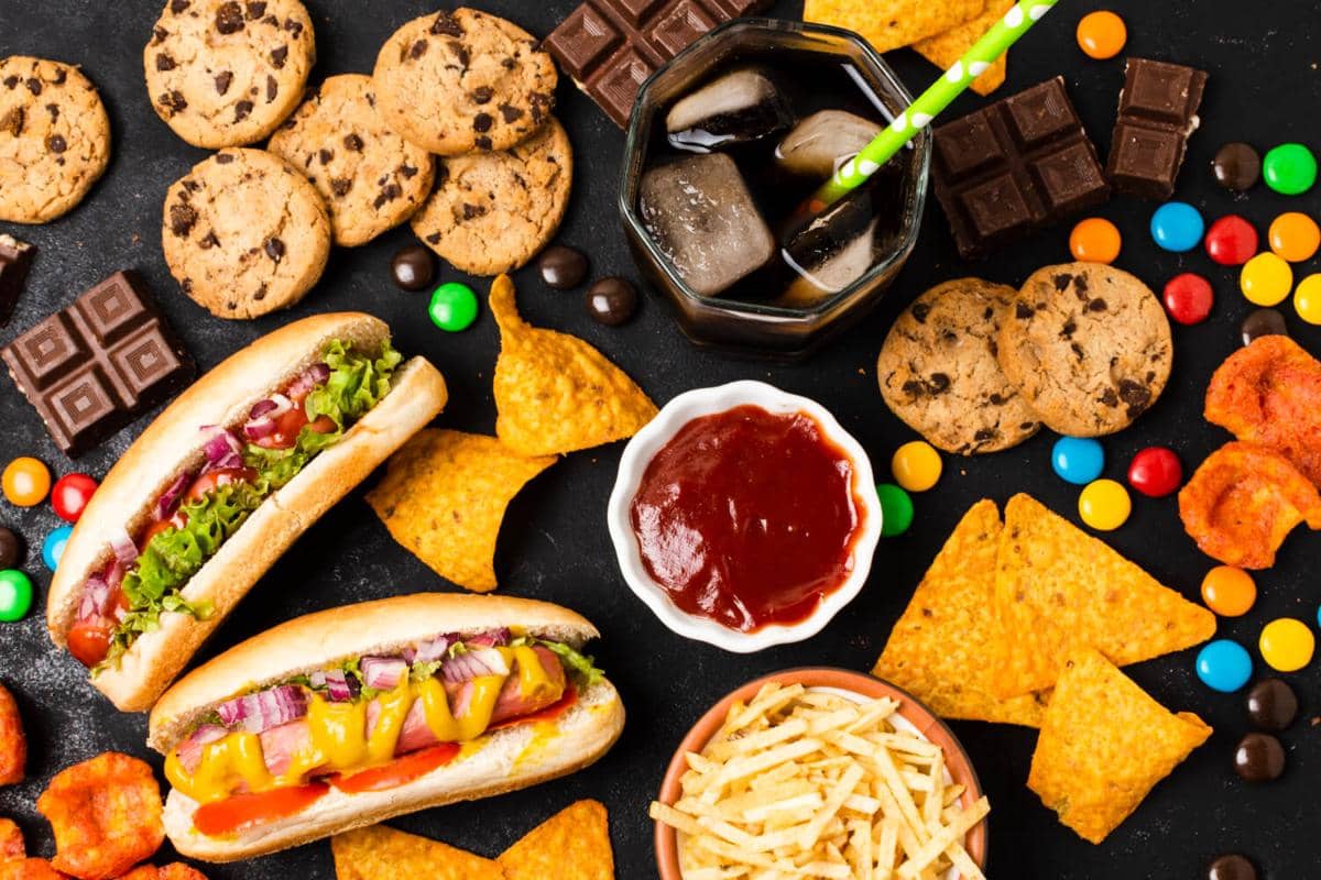 Ilustrasi berbagai makanan ultra proses yang menggambarkan produk pangan siap saji, kemasan, dan olahan industri.
