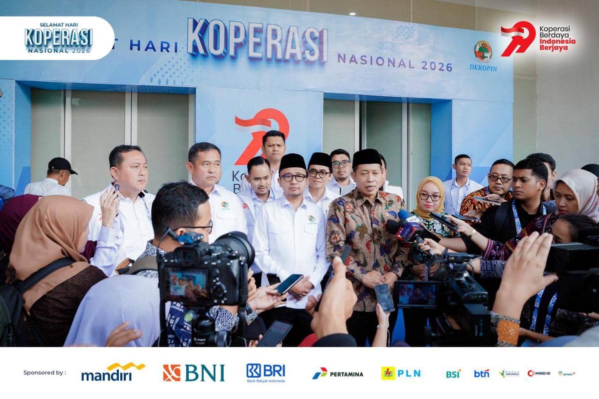 Sejumlah pejabat Dekopin memberikan keterangan pers di depan backdrop Hari Koperasi Nasional 2026 di Indonesia Arena.