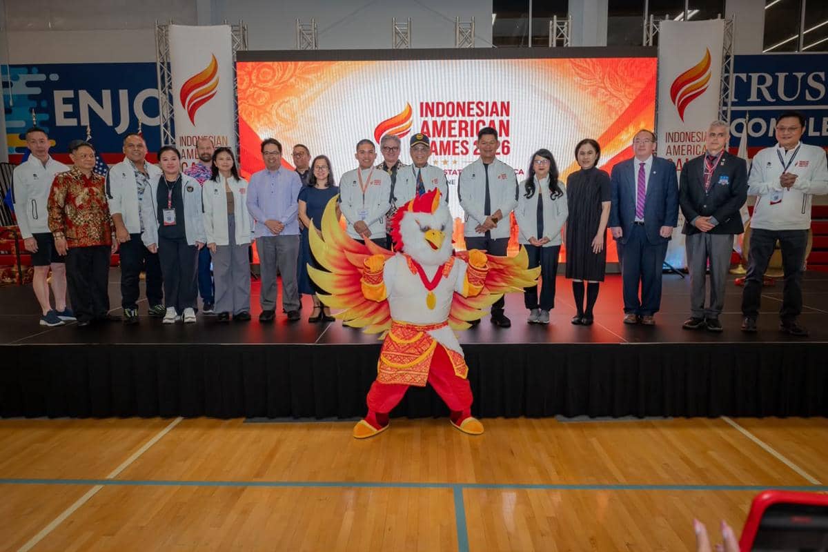 Panitia dan peserta berfoto bersama maskot burung garuda di acara peluncuran Indonesian American Games 2026 di atas panggung dalam ruangan.