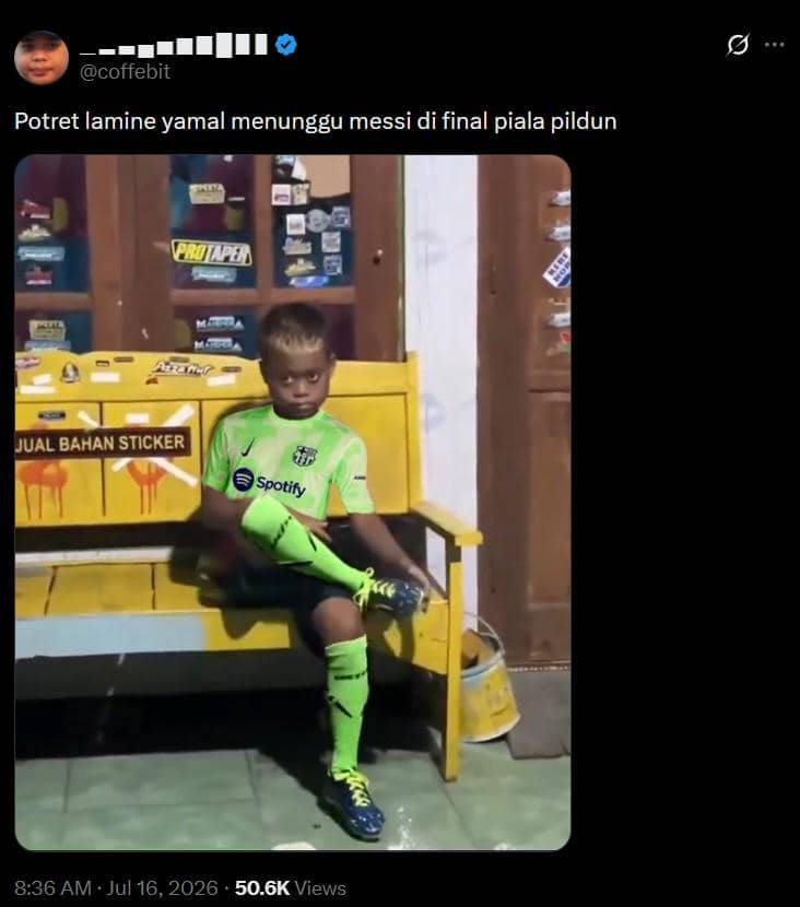 Seorang anak mengenakan seragam sepak bola hijau duduk di bangku kuning dengan kaki bersilang di depan etalase toko kecil.