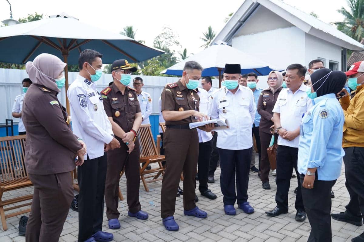 Kajati Lampung bersama sejumlah pejabat memantau pelaksanaan program MBG di Tanggamus sambil meninjau dokumen di area terbuka.