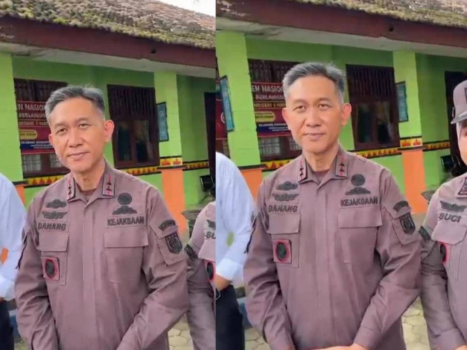 Seorang pejabat Kejaksaan mengenakan seragam cokelat berdiri di depan bangunan sekolah berwarna hijau dan oranye di Natar, Lampung Selatan.