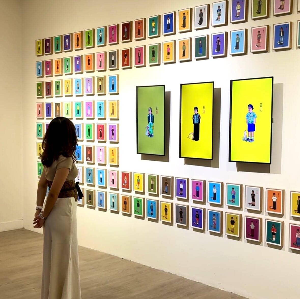 Seorang pengunjung melihat deretan karya seni berwarna cerah yang dipajang di dinding galeri dalam pameran ARTJOG 2026.
