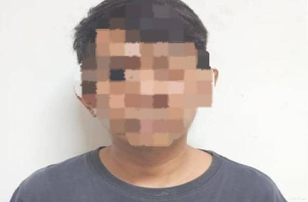Seorang pria berkaus gelap dengan wajah diblur oleh pihak kepolisian terkait kasus pengoplosan gas elpiji di Banyumas.
