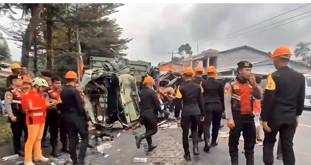 Petugas kepolisian dan tim penyelamat menangani kecelakaan maut di Sibolangit dengan kondisi kendaraan rusak parah di pinggir jalan.