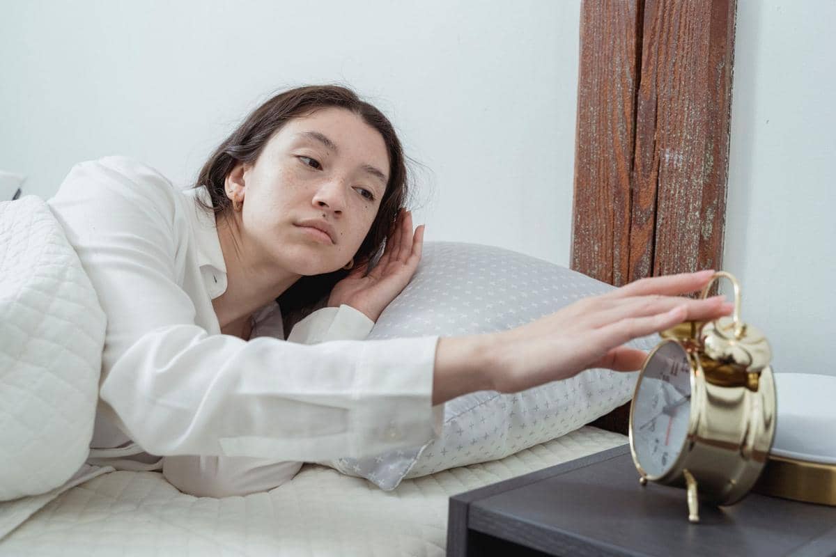seorang perempuan mematikan jam weker