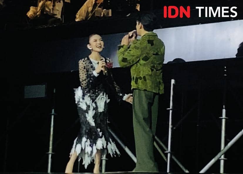Dua penyanyi tampil di atas panggung konser Afgan Retrospektif di Plenary Hall JICC Jakarta, saling bernyanyi dan tersenyum.