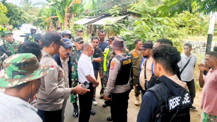 Aparat gabungan TNI dan Polri berdiskusi di jalan desa Adonara Timur dengan latar pepohonan dan warga sekitar yang menyaksikan.