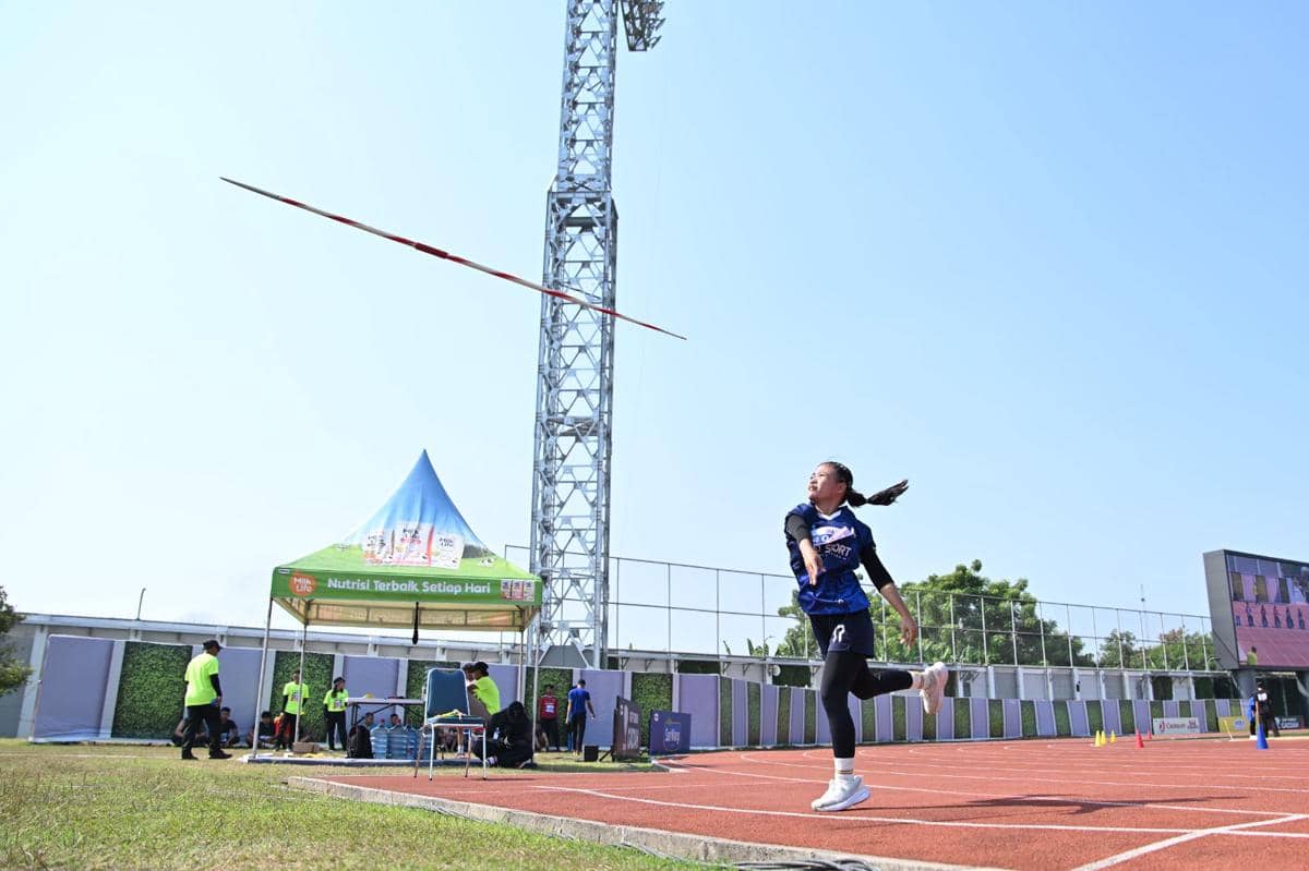 Seorang atlet perempuan melempar lembing di lintasan stadion saat ajang MilkLife Athletics Challenge Seri 1 2026 berlangsung di bawah langit cerah.