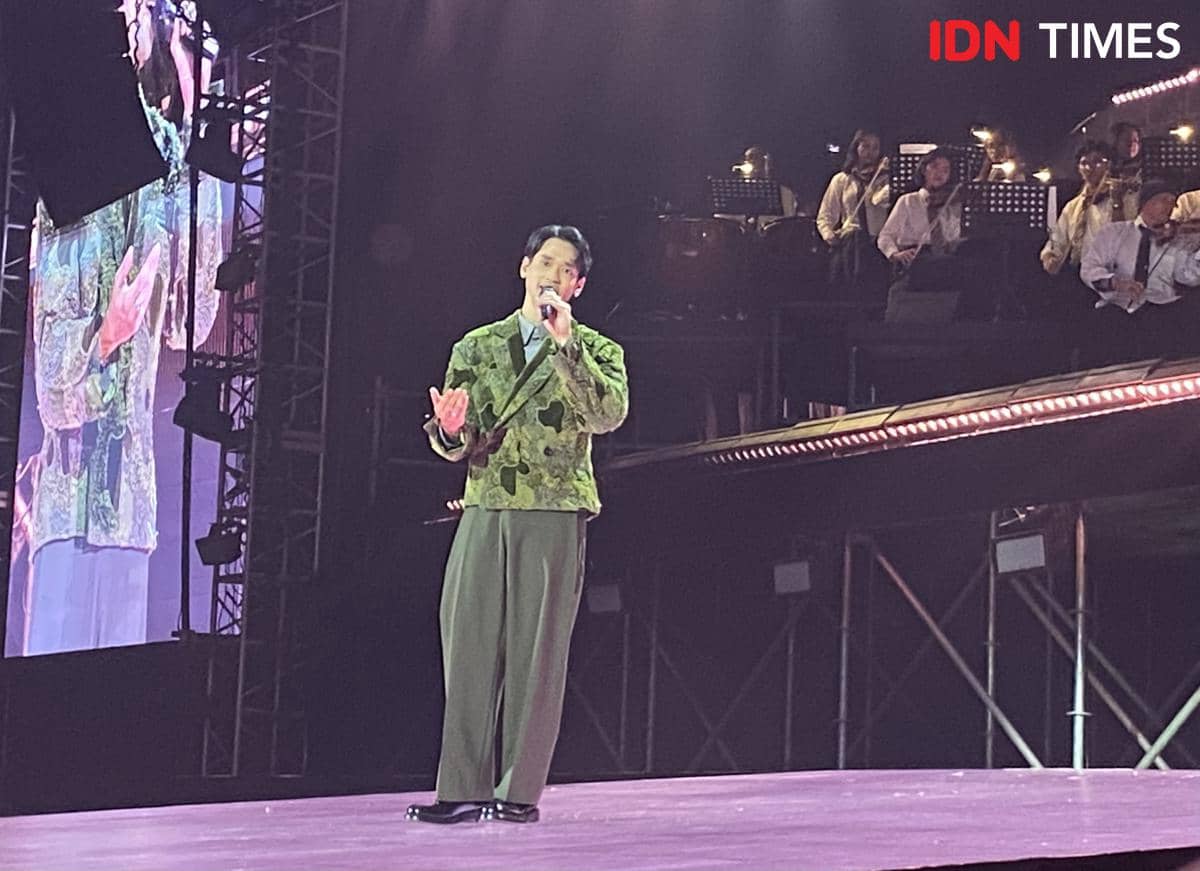Afgan tampil di atas panggung mengenakan jas hijau bermotif saat konser Afgan Retrospektif di Plenary Hall JICC Jakarta.