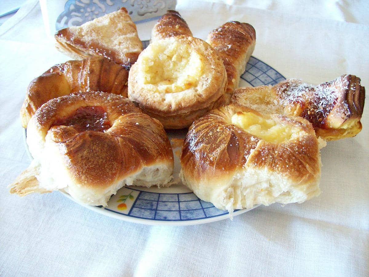 Beberapa potong facturas, kue khas Argentina dengan berbagai isian manis seperti krim dan selai, tersaji di atas piring keramik.