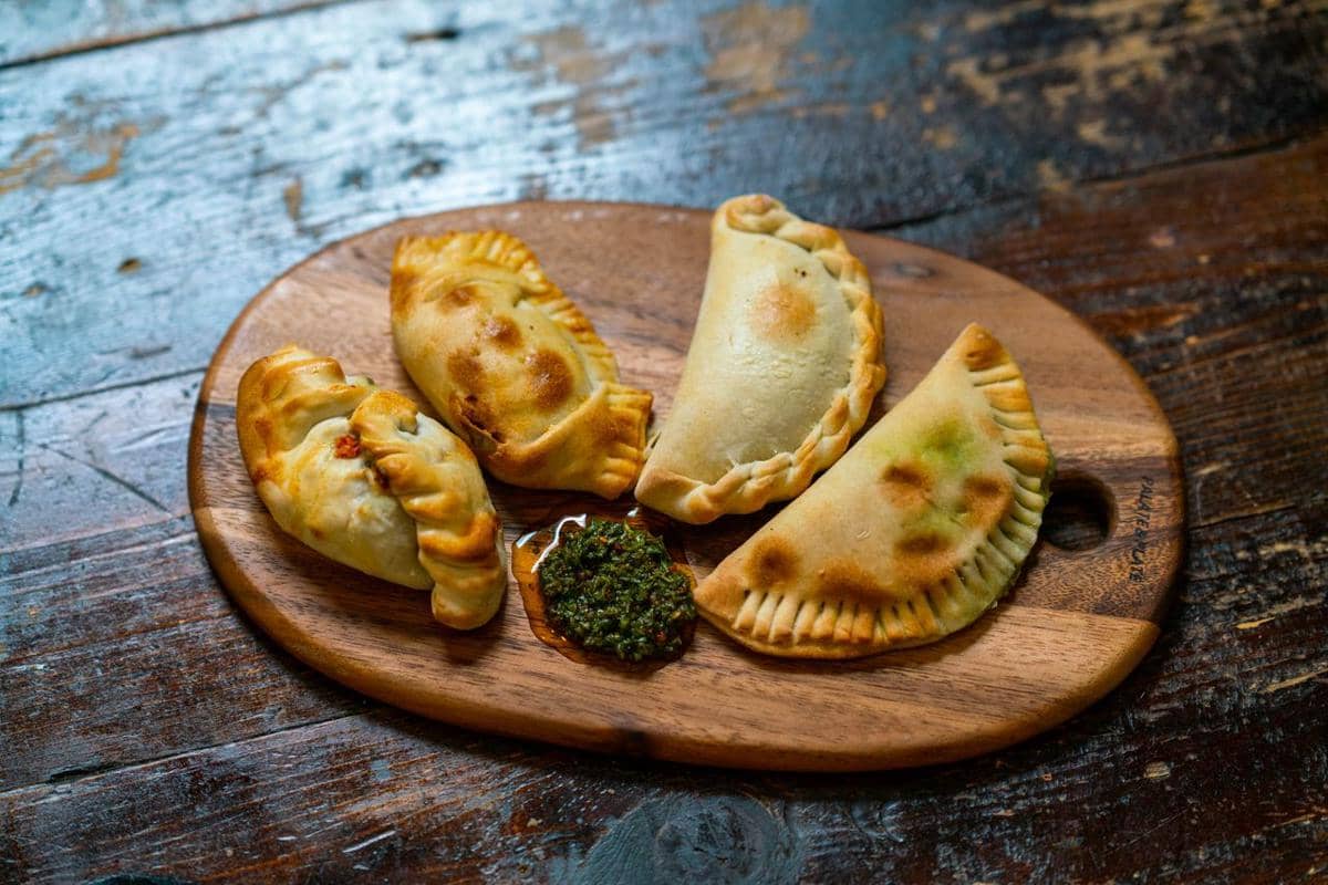 https://www.pexels.com/photo/close-up-shot-of-delicious-empanadas-on-wooden-chopping-board-13689919/