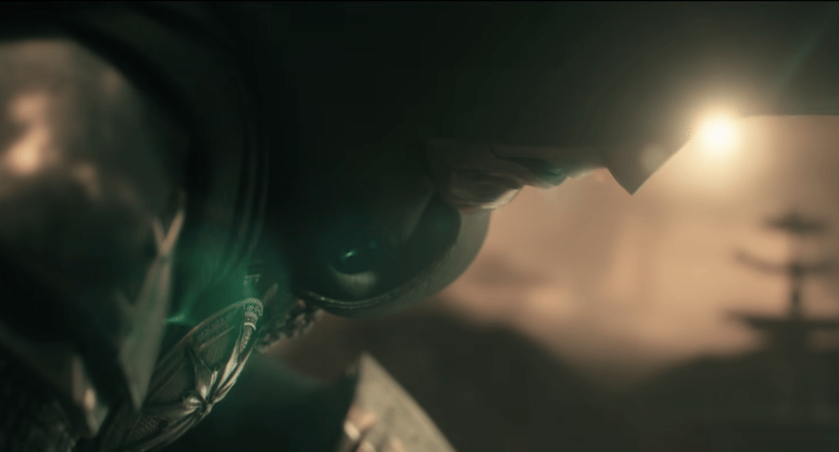 Karakter Doctor Doom mengenakan baju zirah logam dengan cahaya hijau samar di sekitarnya, berlatar suasana gelap dan misterius.