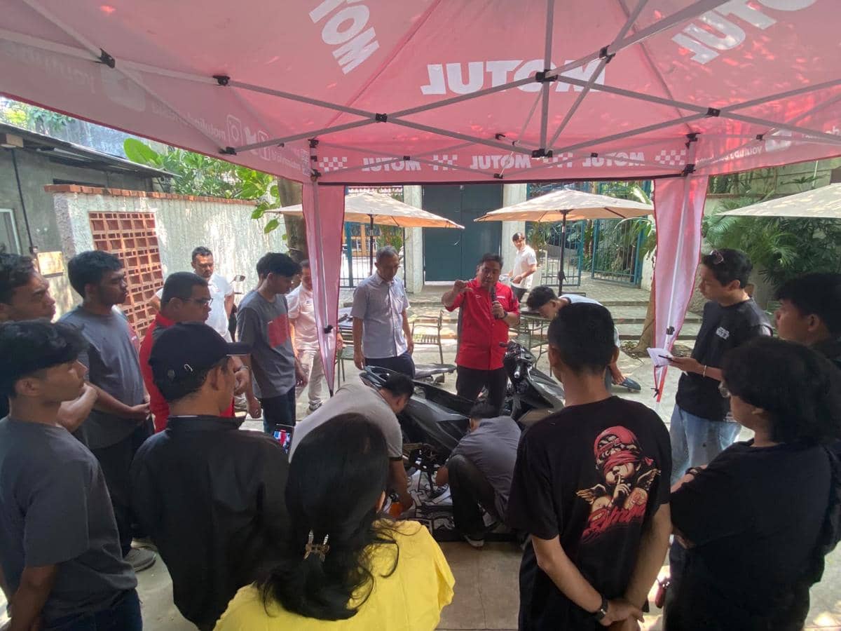 Sejumlah peserta mengikuti pelatihan mekanik sepeda motor di bawah tenda bermerek Motul dengan instruktur memberikan penjelasan.