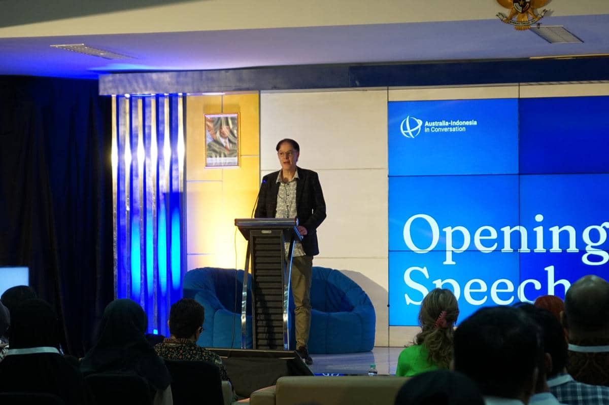 Seorang pembicara berdiri di podium menyampaikan pidato pembukaan di forum Australia-Indonesia in Conversation di FISIPOL UGM.