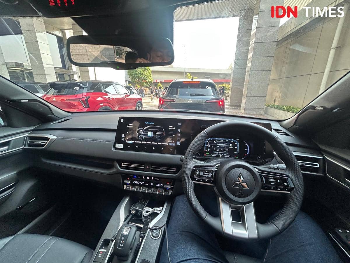 Tampilan interior kokpit Mitsubishi New Xforce Hybrid dengan setir modern, layar digital besar, dan kontrol fitur di konsol tengah.