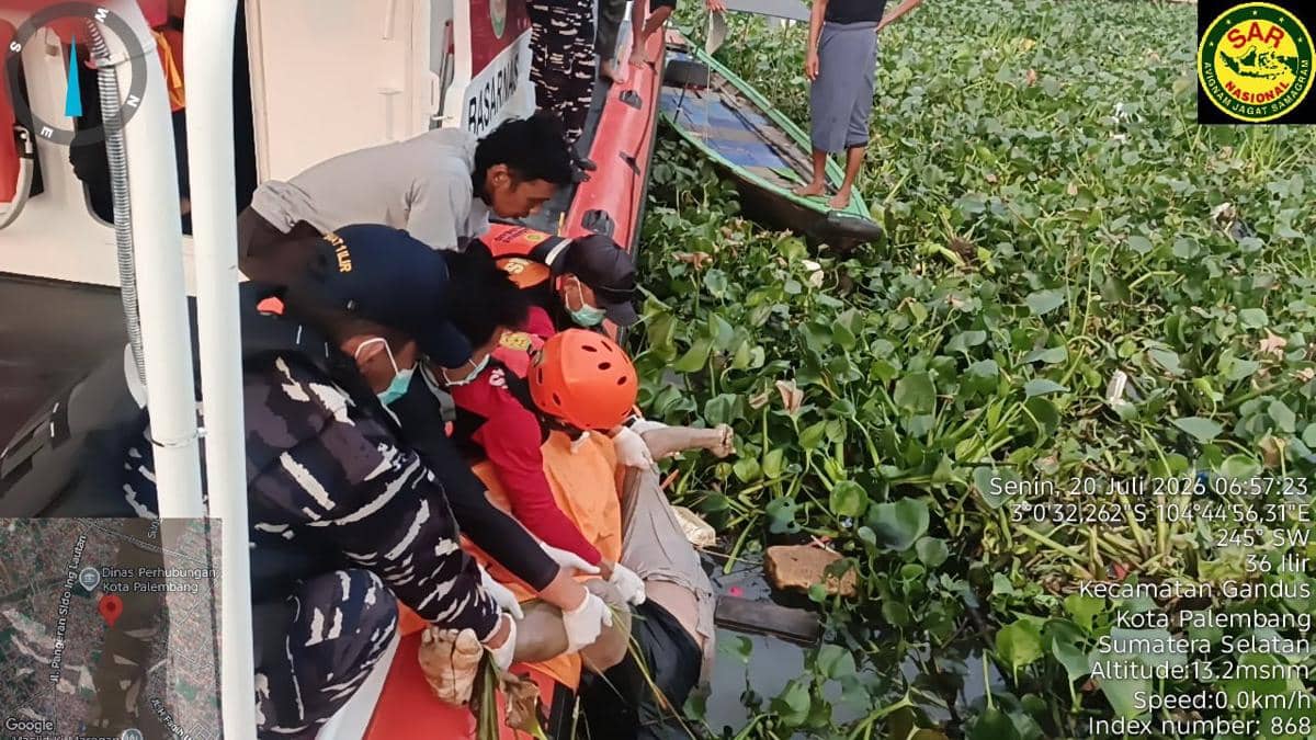 Tim Basarnas Palembang mengevakuasi korban hilang dari Sungai Musi menggunakan perahu di antara tanaman air yang lebat.