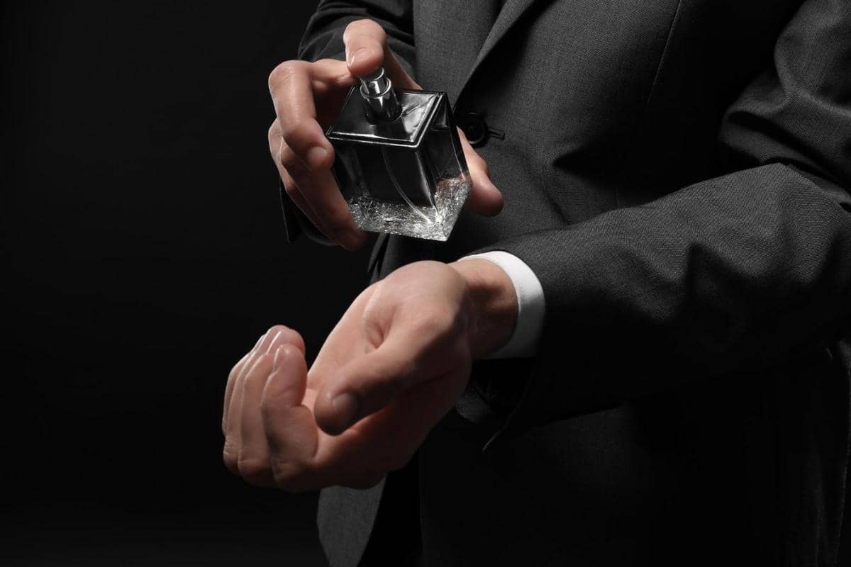 Ilustrasi botol parfum alkohol dan nonalkohol dengan bunga serta cairan berwarna merah muda di latar putih.