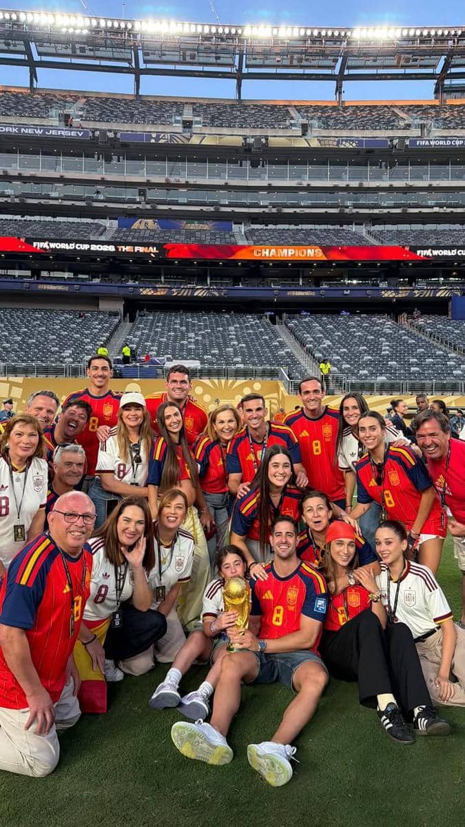 Para keluarga dan pasangan pemain tim nasional Spanyol berpose di stadion sambil merayakan kemenangan Piala Dunia 2026 dengan trofi emas.