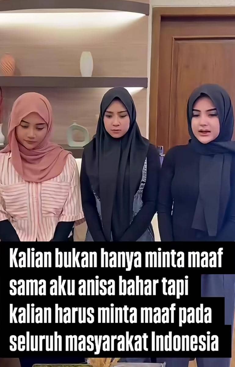 Tiga perempuan berhijab berdiri berdampingan dengan ekspresi serius di dalam ruangan, di depan teks permintaan maaf kepada masyarakat Indonesia.