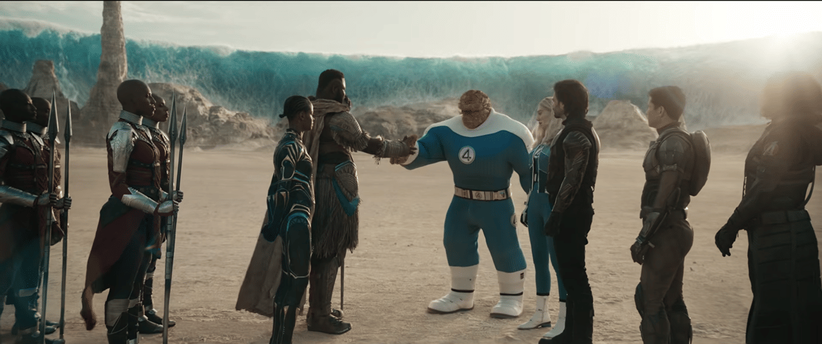 M'Baku dari Wakanda berjabat tangan dengan The Thing dari Fantastic Four di gurun luas dengan rombongan kedua pihak menyaksikan.