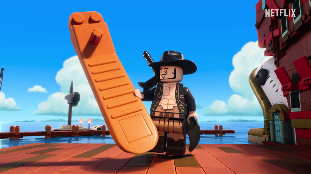 Figur LEGO Dracule Mihawk memegang LEGO Brick Separator berwarna oranye di dermaga dengan latar laut dan kapal LEGO.