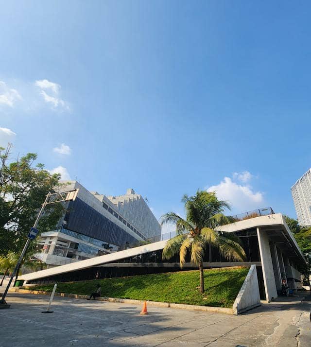 Bangunan modern di salah satu sudut Taman Ismail Marzuki dengan langit biru cerah dan pepohonan di sekitarnya.