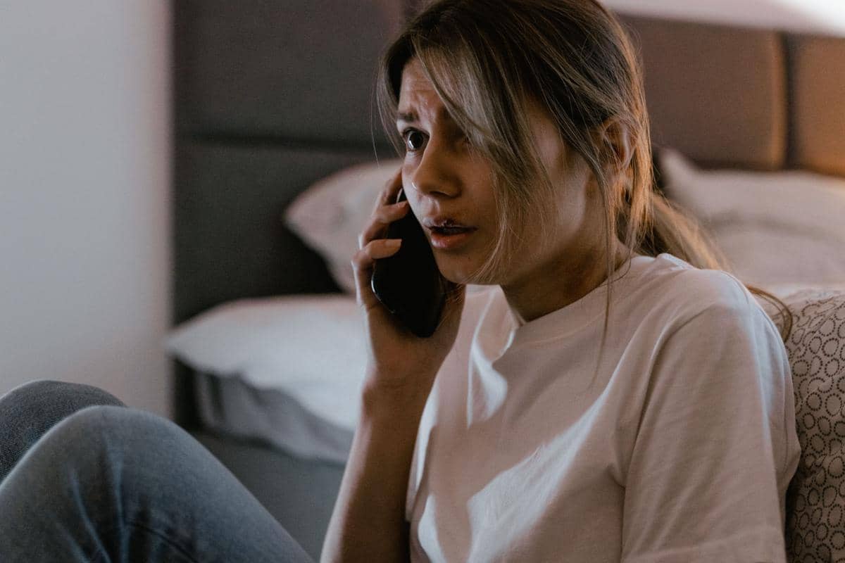 Seorang perempuan tampak cemas saat menerima panggilan telepon 