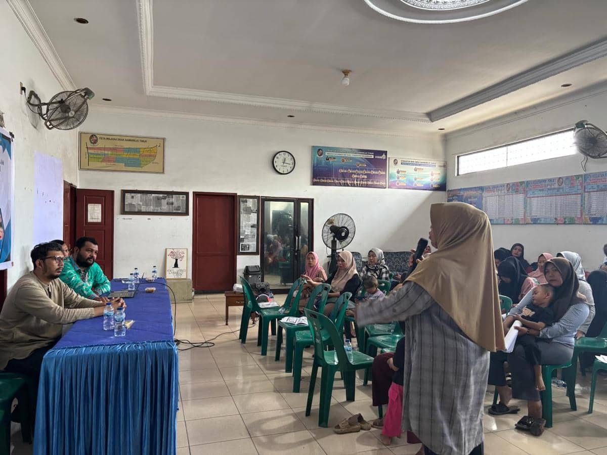 Kegiatan sosialisasi FIK Unimed di Desa Sambirejo Timur, Deli Serdang, dengan peserta duduk mendengarkan pemaparan narasumber di aula desa.
