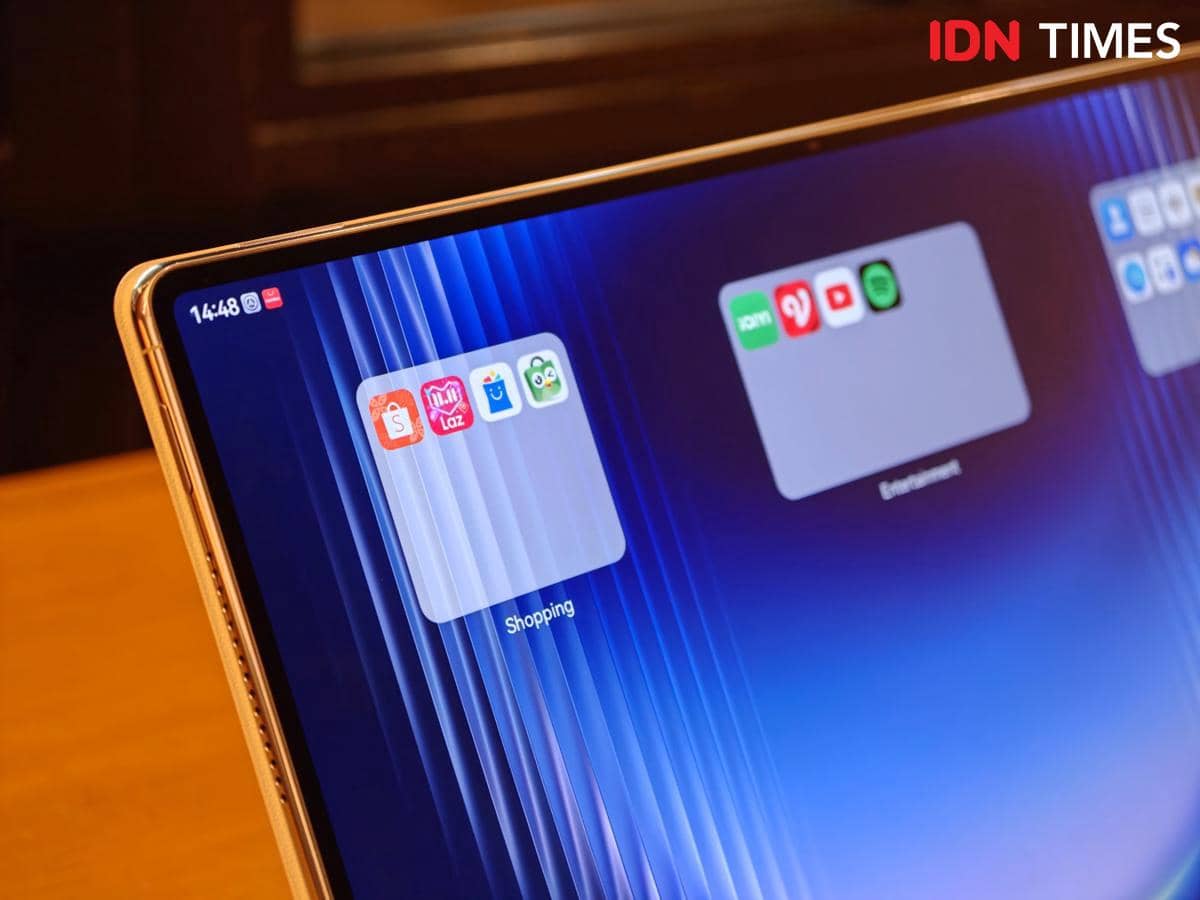 Tampilan layar tablet HUAWEI MatePad Pro Max dengan folder aplikasi bertema Shopping dan Entertainment di atas meja kayu.