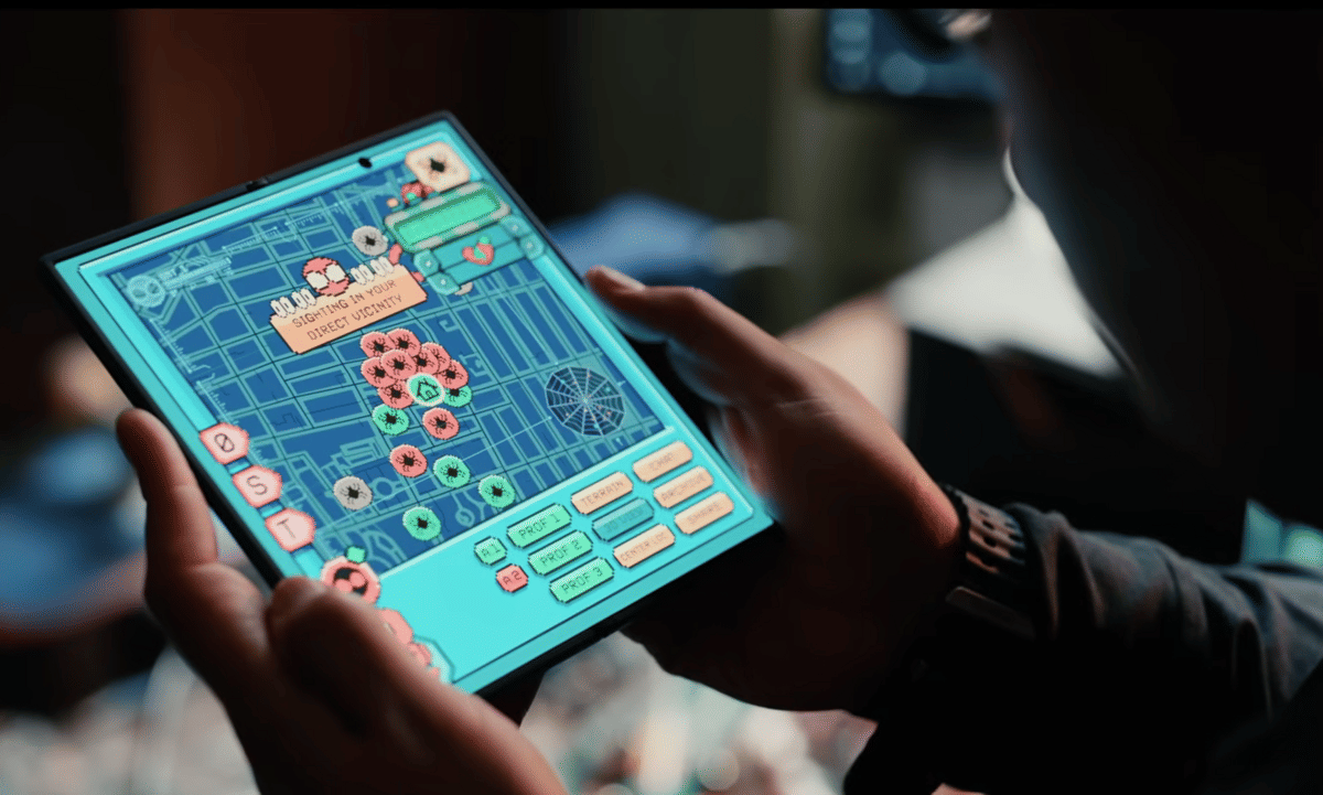 Seseorang memegang tablet yang menampilkan aplikasi Spider-Tracker dengan peta digital dan ikon berwarna di layar.