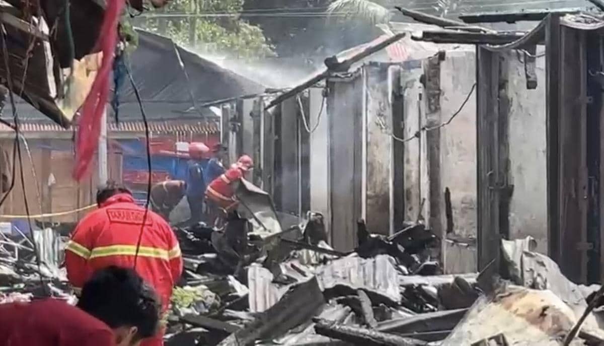Petugas pemadam kebakaran berusaha memadamkan sisa api dan membersihkan puing bangunan yang terbakar di Kayu Tanam, Padang Pariaman.