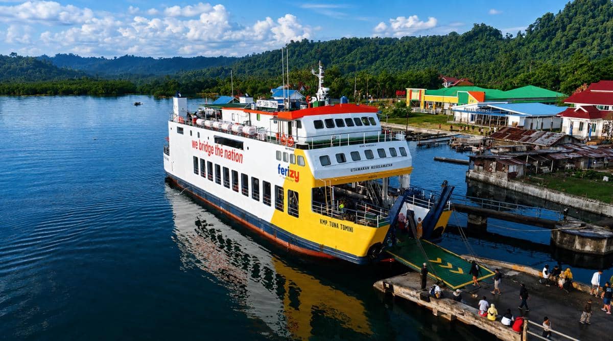 Kapal ferry KMP Tuna Tomini milik PT ASDP Indonesia Ferry bersandar di pelabuhan Luwuk, Sulawesi Tengah, dengan latar perbukitan hijau.