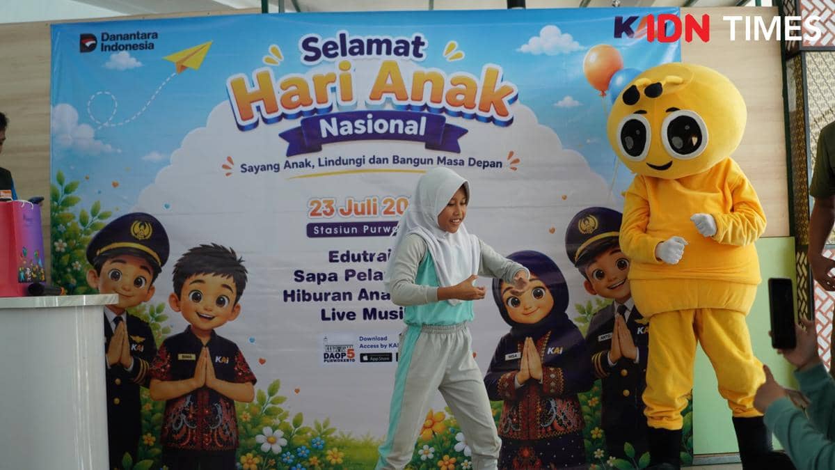 Seorang siswi SD mengenakan seragam olahraga tampil pantomim di depan maskot berwarna kuning saat perayaan Hari Anak Nasional di Purwokerto.