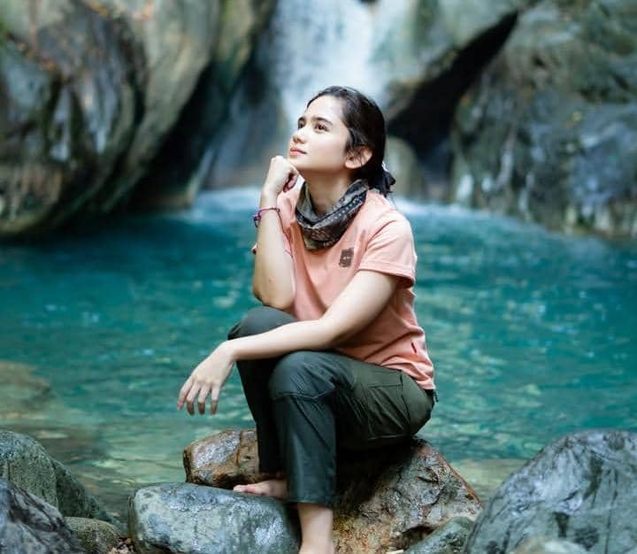 Tissa Biani berpose saat trekking di jalur Curug Sentul dengan latar pepohonan dan suasana alam yang asri.