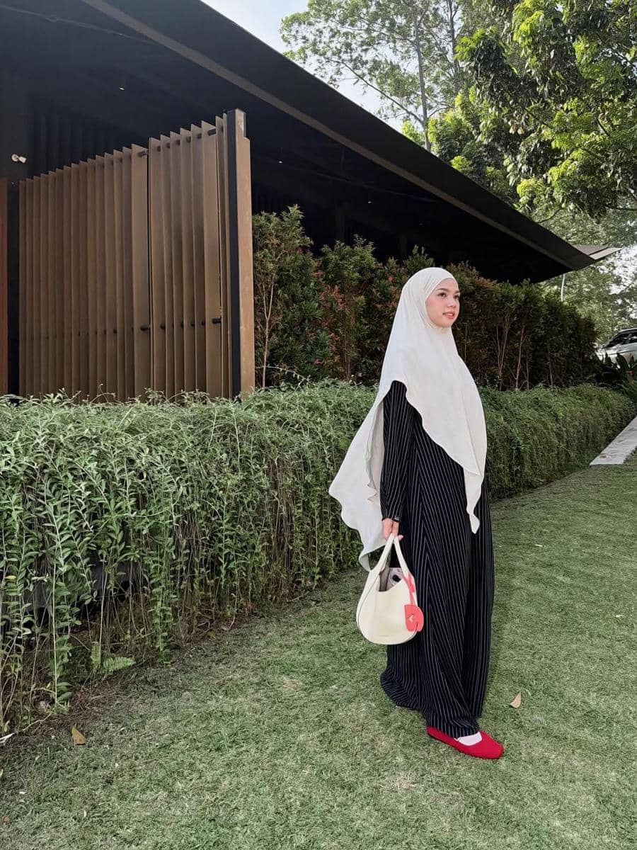 Alfi Siregar mengenakan outfit hijab modis dengan kerudung yang menutup dada sebagai inspirasi gaya berpakaian.