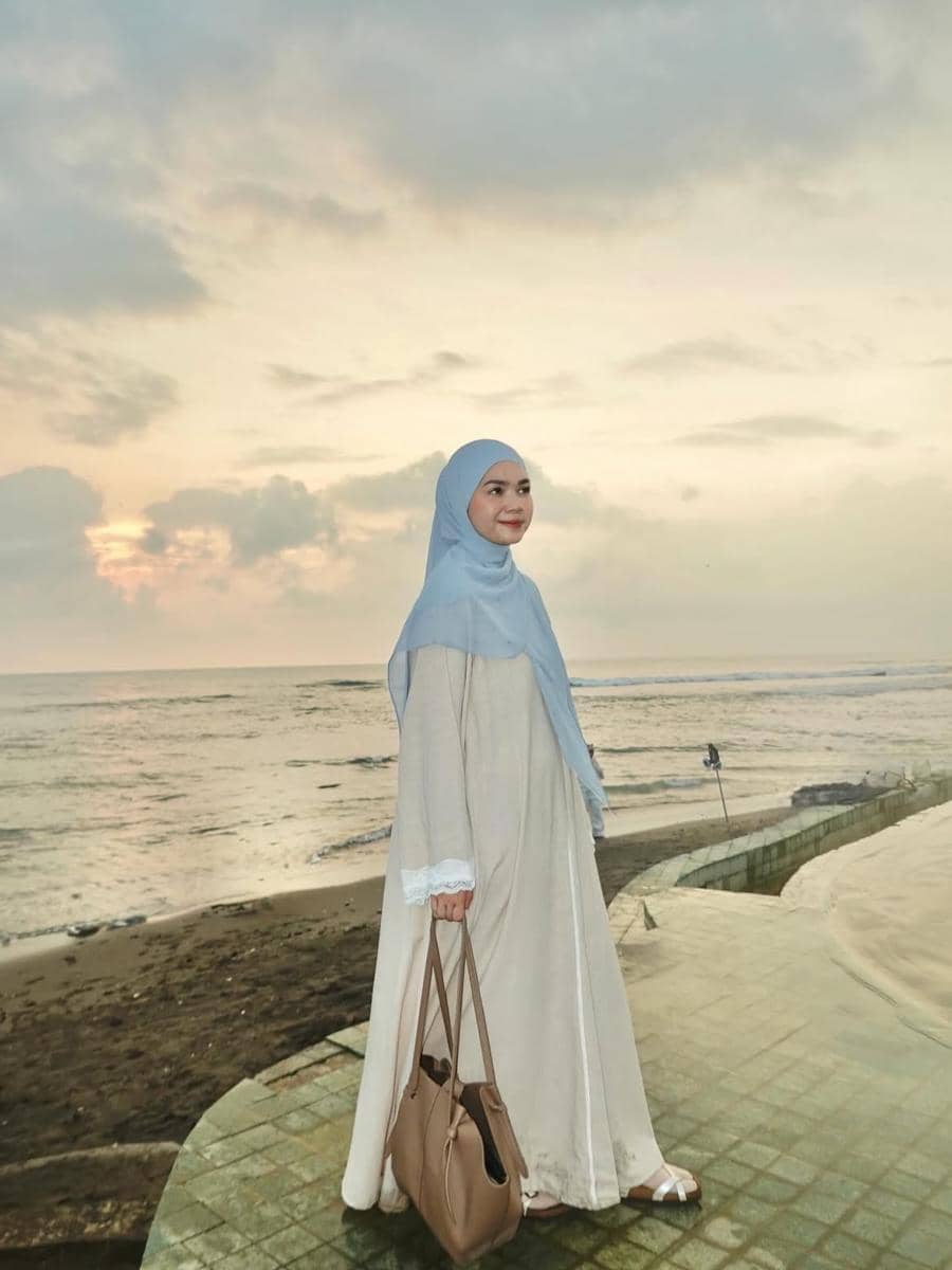 Alfi Siregar mengenakan hijab yang menutup dada dengan padu padan busana modest untuk tampilan modis sehari-hari.