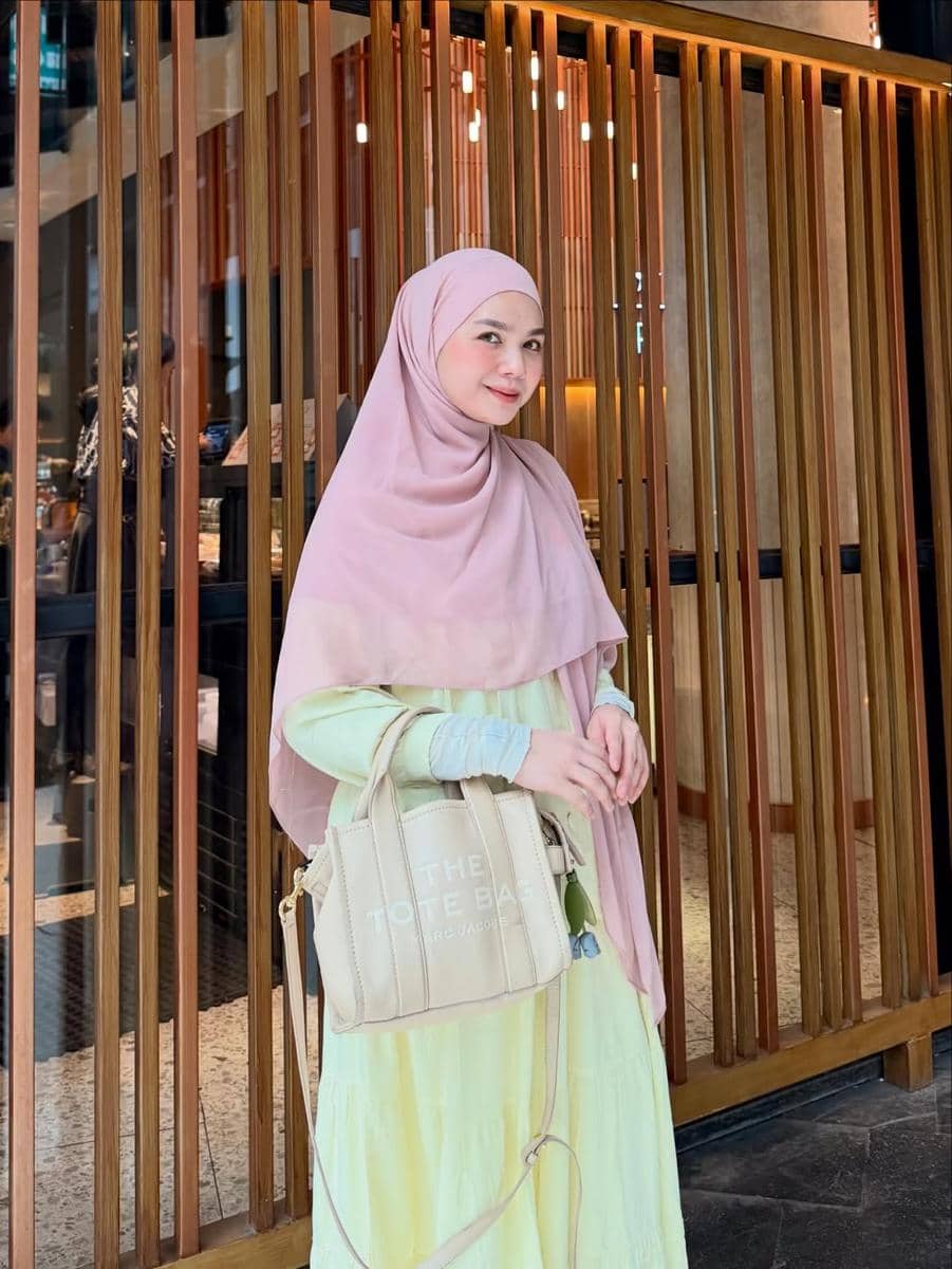 Alfi Siregar mengenakan outfit hijab modis bergaya menutup dada sebagai inspirasi busana muslim sehari-hari.