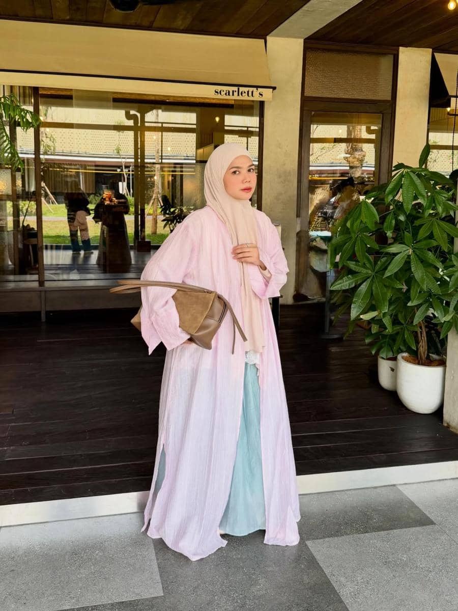 Alfi Siregar mengenakan outfit hijab modis dengan gaya busana yang menutup bagian dada untuk inspirasi penampilan sehari-hari.