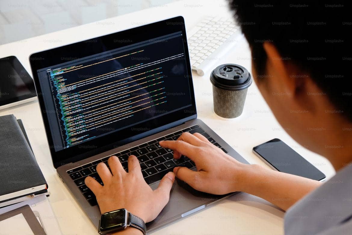 Seorang programer sedang bekerja di depan laptop